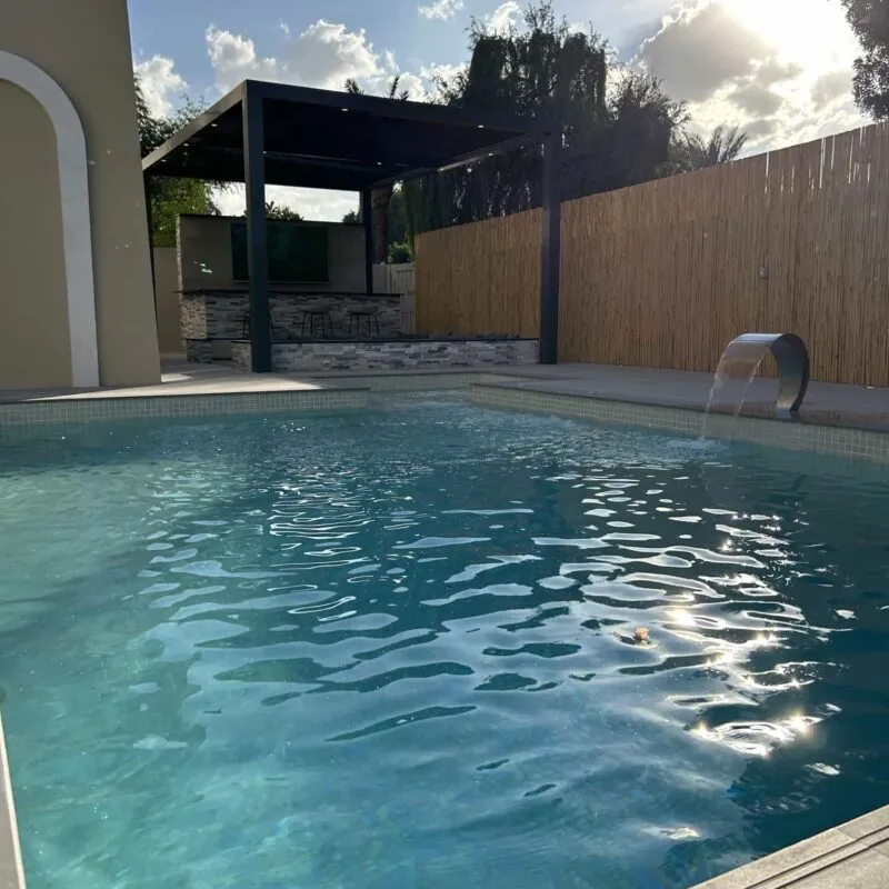 Villa swimming pool with water feature and timber screen in Dubai by MasterMaint
