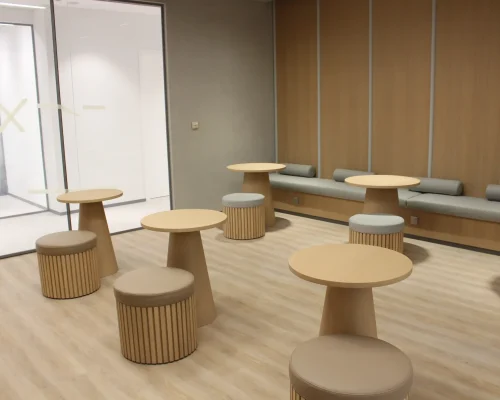 Landscape Design 6 Modern office lounge interior with light wood flooring, wooden wall paneling and round cafe tables with built-in bench seating - interior fit out Dubai