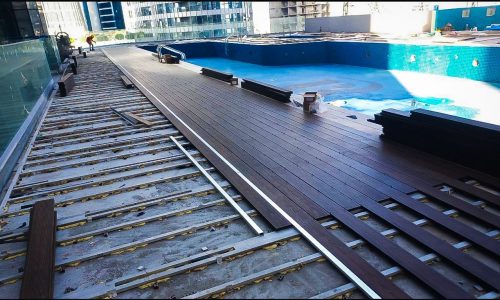 WPC wood decking and flooring installation work around rooftop swimming pool - rooftop decking installation Dubai