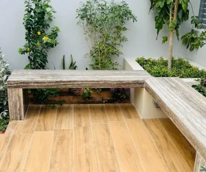 Custom wood-composite decking area with a built-in bench and vertical garden background in a Dubai villa.