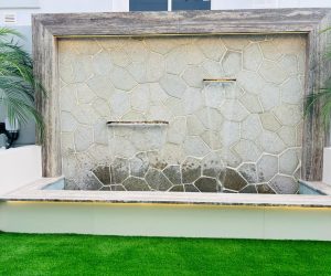 arrow side-yard garden layout with concrete stepping stones and green perimeter plants in a Dubai property.