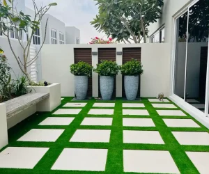 Custom wood-composite decking area with a built-in bench and vertical garden background in a Dubai villa.