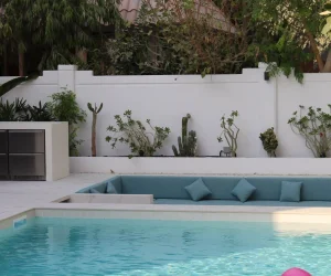 Custom submerged pool steps with non-slip blue mosaic tiling in an in-ground Dubai swimming pool.