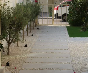 Mediterranean style villa entryway with stone arch and landscaped garden path in Dubai.